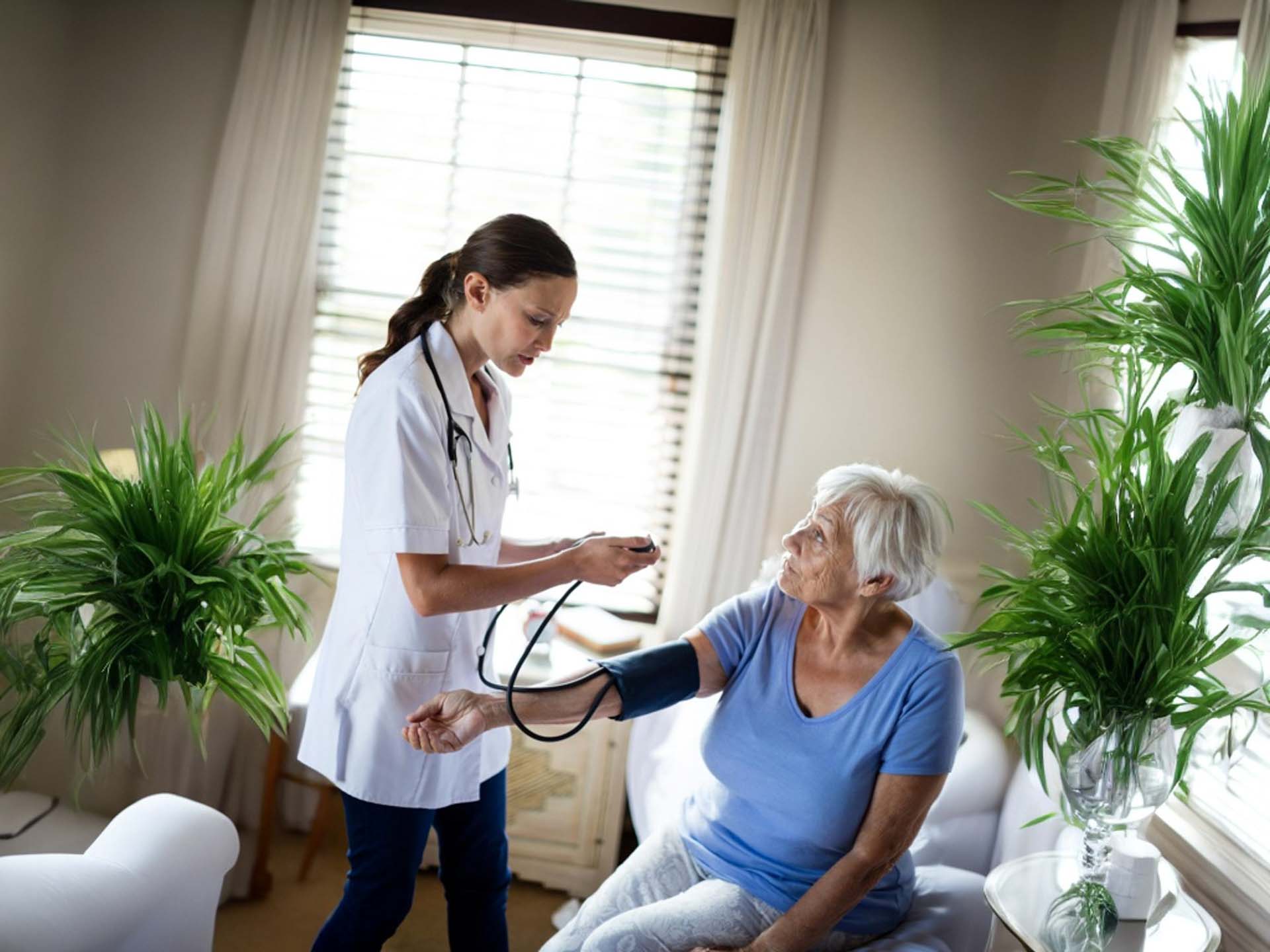 Nurse helping elderly person in their home